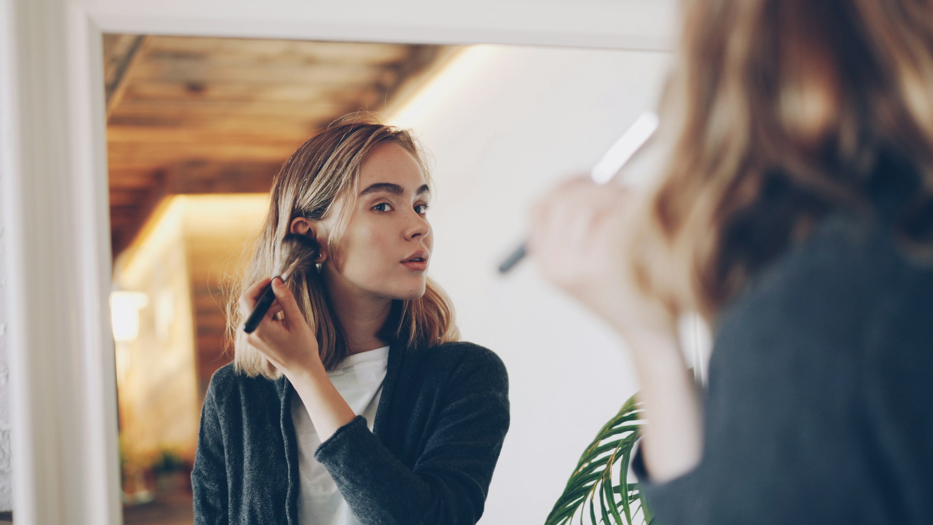 Everyday Beauty Tips for a Polished Look Young woman applying makeup in mirror