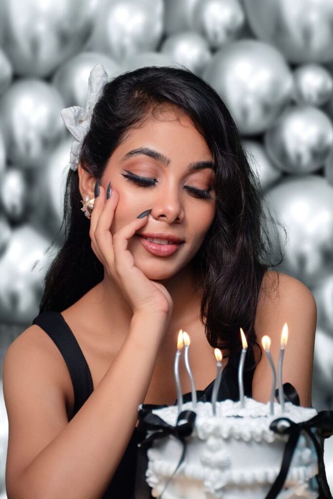 Crafting Captivating Headlines: Your awesome post title goes here Young woman with long hair celebrates her birthday with a cake adorned with candles in a studio setting.
