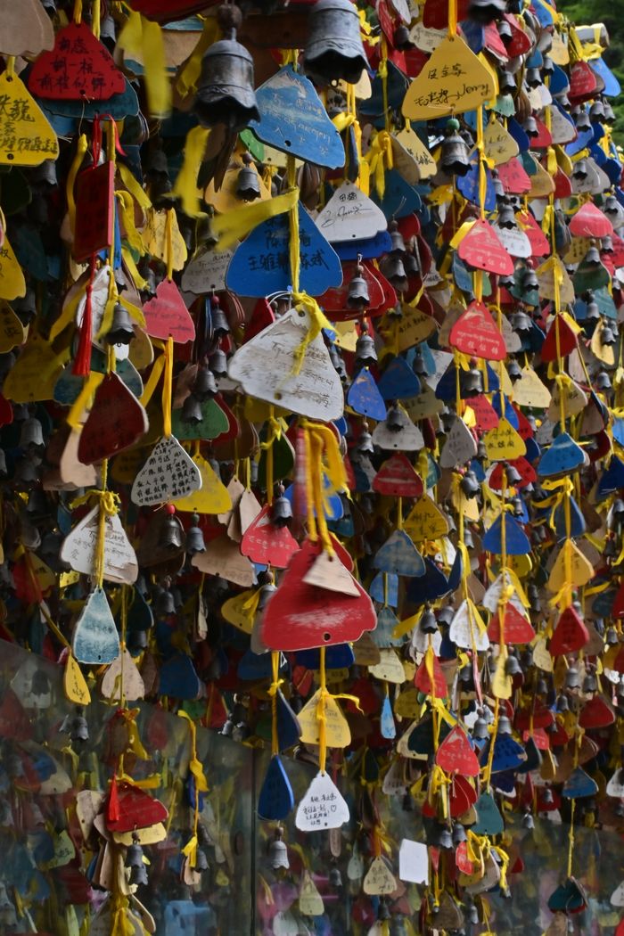 Vibrant outdoor display of colorful hanging wishes with bells attached.