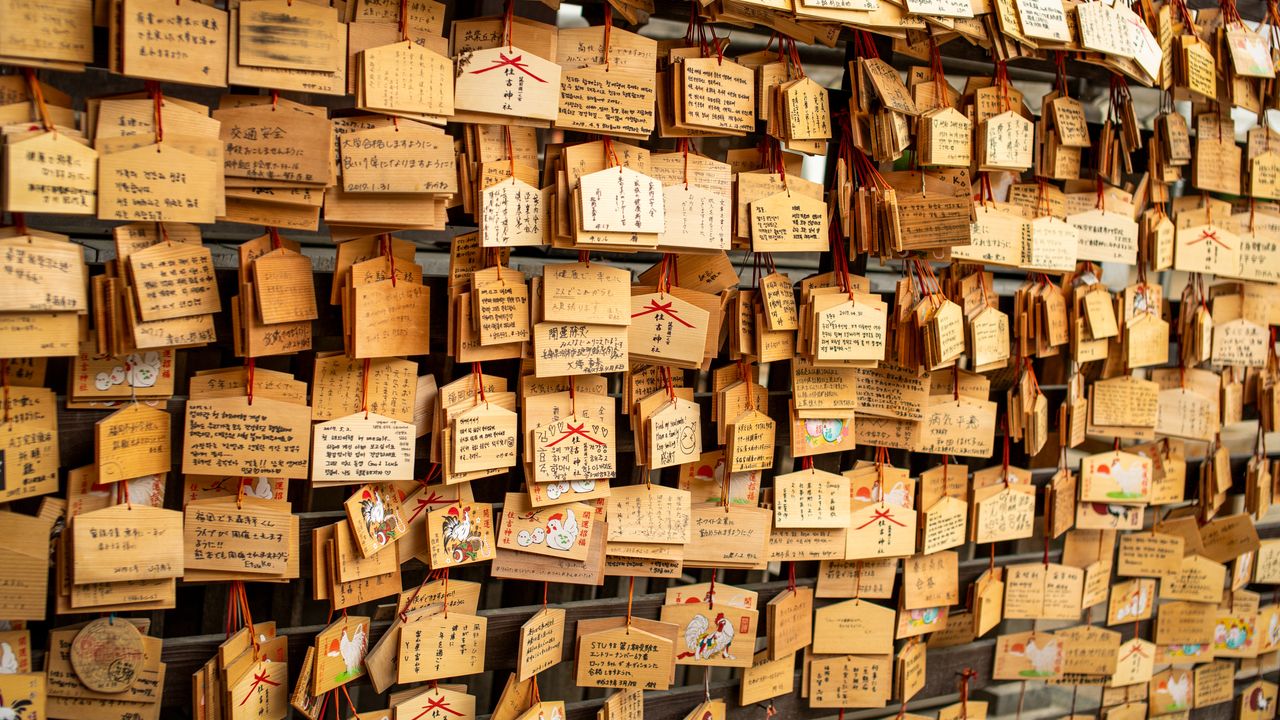 Traditional ema boards with handwritten wishes on display at a shrine in Fukuoka, Japan.